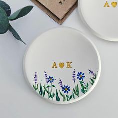 two personalized plates sitting on top of a table next to a potted plant