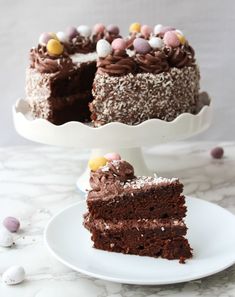 a slice of chocolate cake on a white plate with an egg in the middle and one piece missing