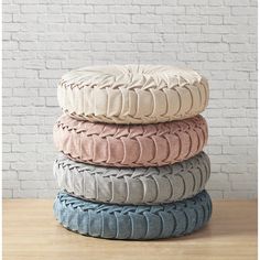 four different colored tires stacked on top of each other in front of a brick wall