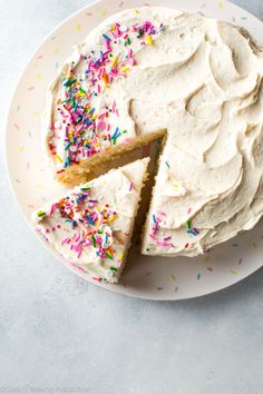 a cake with white frosting and sprinkles on a plate