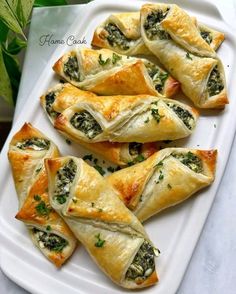 spinach and cheese pastries on a white platter