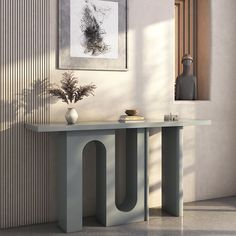 a modern console table with two vases and a painting on the wall behind it