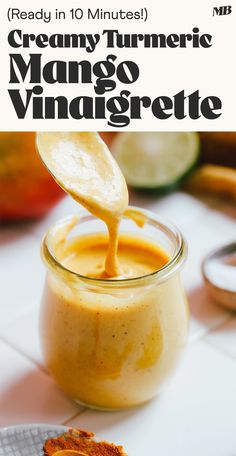 creamy turment mango vinagrete is being poured into a jar