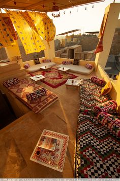 an outdoor seating area with rugs and pillows