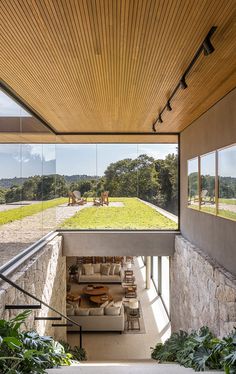 the inside of a house with large windows and grass on the roof, as well as an outdoor living area