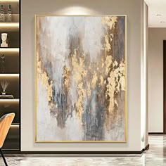 an abstract painting hangs on the wall next to a chair and table in a modern living room