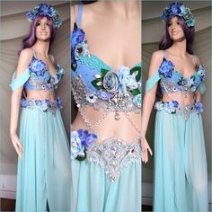 a woman wearing a blue dress with flowers on the top and bottom, in front of a mannequin