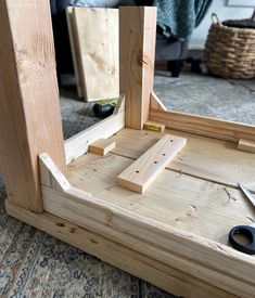 a wooden frame with scissors and pliers on the floor