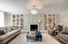 a living room filled with furniture and a fire place in front of a book shelf