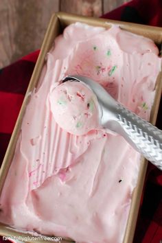 a scoop of ice cream in a wooden box with a metal spoon next to it