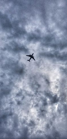 an airplane is flying through the cloudy sky