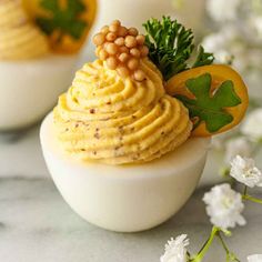 two small white bowls filled with food on top of a table