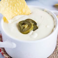 a white bowl filled with dip and a tortilla chip