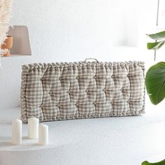 a white shelf with some candles and a purse on it