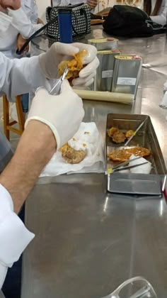 some people in white gloves are preparing food