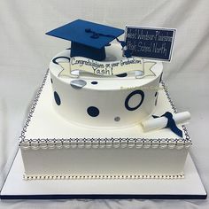 a graduation cake is decorated with blue and white polka dots, a mortar cap on top