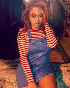 a woman in overalls and makeup posing for the camera