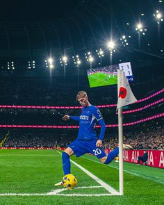 a man kicking a soccer ball on top of a field