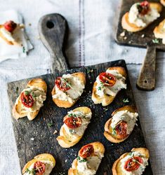 small appetizers are arranged on a wooden cutting board