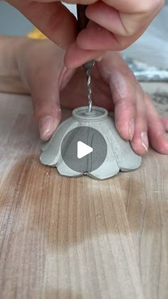 a person is pouring water into a small elephant shaped object on top of a wooden table