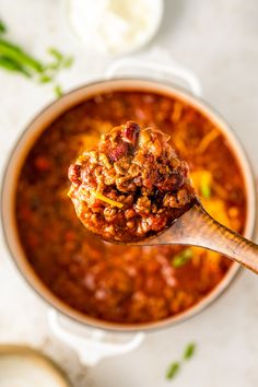 a spoon full of chili and meat soup