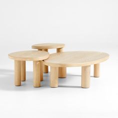 two wooden tables sitting next to each other on top of a white floor covered in light colored wood