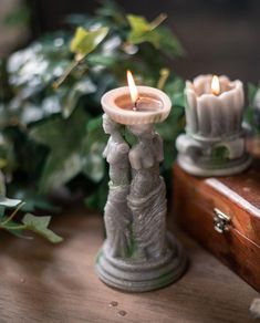 two candles sitting on top of a wooden table