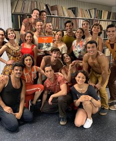 a group of people posing for a photo in front of a bookshelf full of books