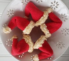 four red knitted hearts in a white bowl on a doily with snowflakes