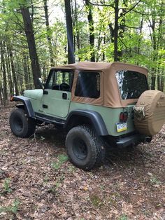 the jeep is parked in the woods with its tent on it's back end