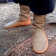 a person standing on top of a rug wearing brown shoes