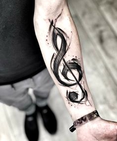 a person with a tattoo on their arm holding a cell phone and a music note