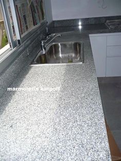 a kitchen counter top with a sink and window