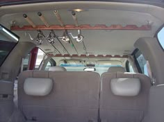 the interior of a vehicle with two seats and an overhead rack in the back area