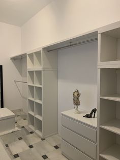 an empty room with white shelving and black shoes