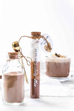 two jars filled with chocolate pudding next to each other on top of a white table