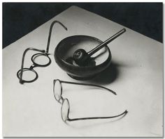 an old black and white photo with glasses, eyeglasses and a bowl on the table