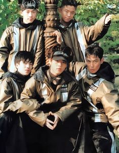 a group of young men standing next to each other in front of a lamp post