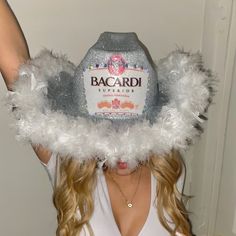 a woman wearing a hat with feathers around her head and the label bacardi on it