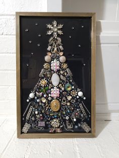 a christmas tree made out of jewelry in a wooden frame