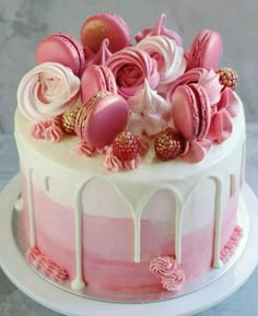 there is a pink and white cake with icing on the top, decorated with flowers