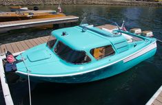 a small blue boat docked at a pier