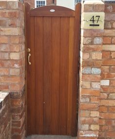 a wooden door is open in front of a brick wall with a number on it