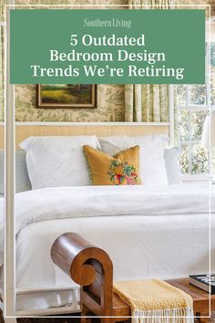 a white bed sitting under a window next to a green sign that says, 5 outdated bedroom design trends we're returning