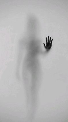 the shadow of a person's hand is shown in black and white, against a light gray background