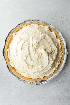 a pie sitting on top of a metal pan covered in frosted icing next to a knife