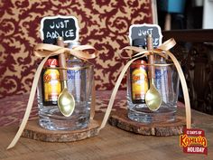 two glass jars with spoons and labels on them