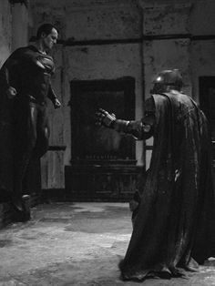 two men dressed as batman and superman returns from the dark knight's castle in black and white