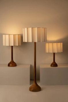 three lamps sitting on top of white blocks