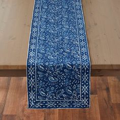 a blue table runner sitting on top of a wooden floor